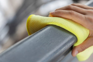 mano con panno giallo in microfibra pulisce