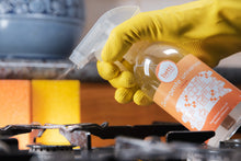 Carica l&#39;immagine nel visualizzatore di Gallery, bottiglia di detergente universale con spruzzino in una mano con guanto giallo in cucina